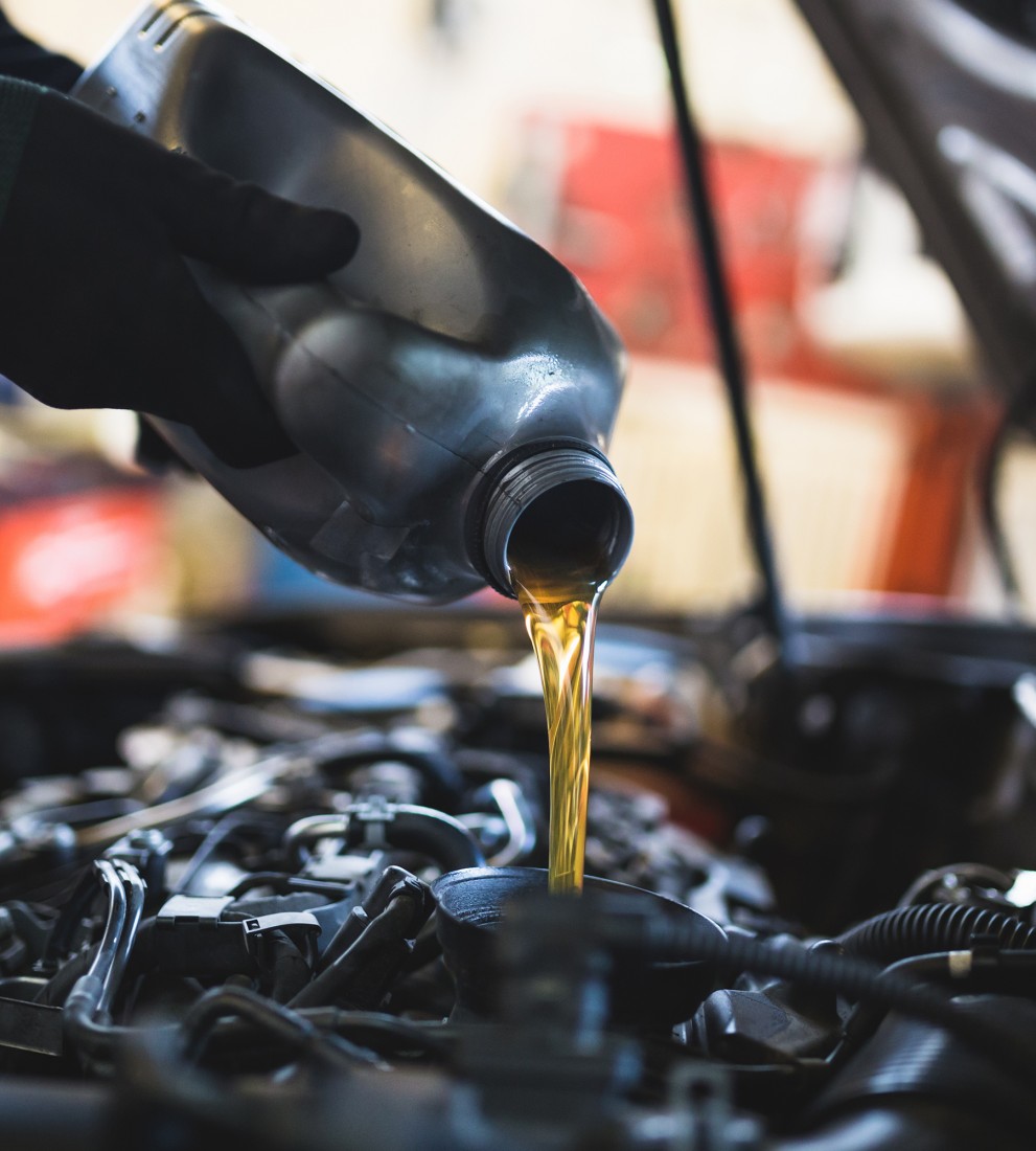 Mechanic pouring liquid into engine